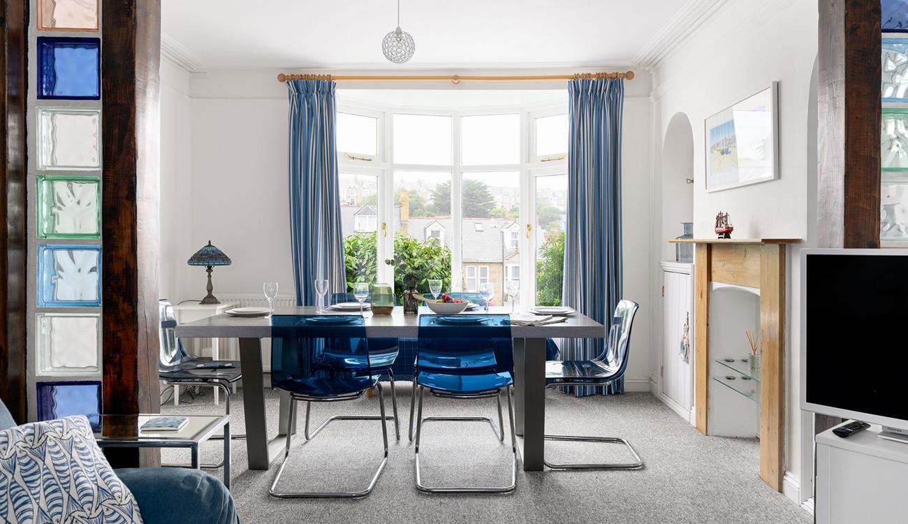 Draw back the curtains and let the light flood into this contemporary dining room through the bay window.