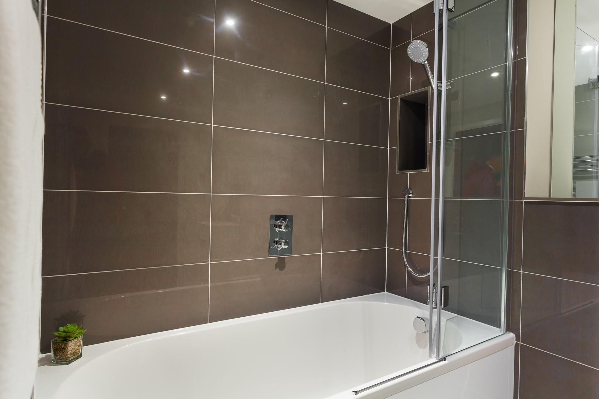 Sleek glossy tiles and a power shower create a spa-like experience for your daily showers. 