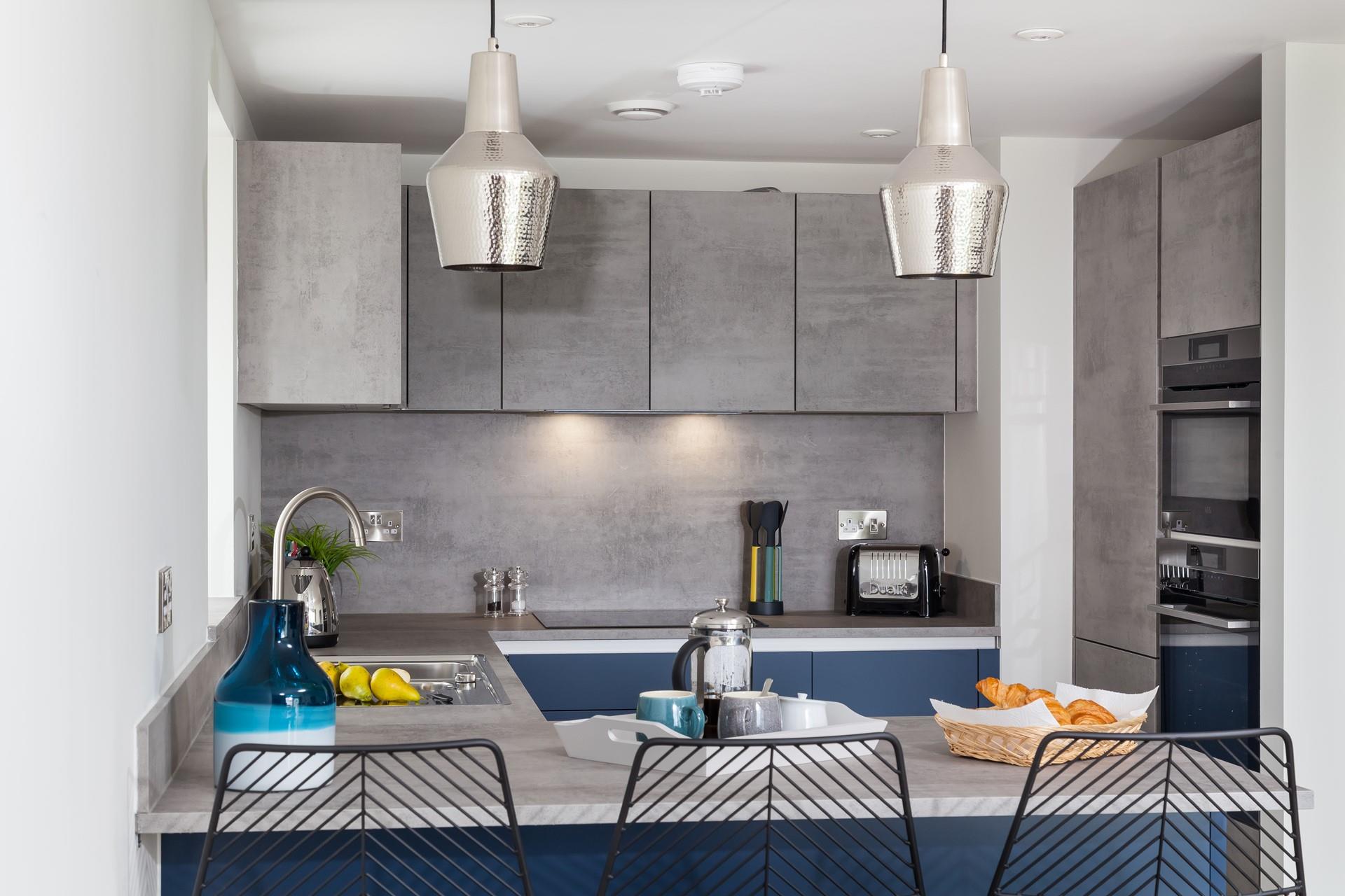 Contemporary and stylish, we love the sleek kitchen design with feature lampshades. 