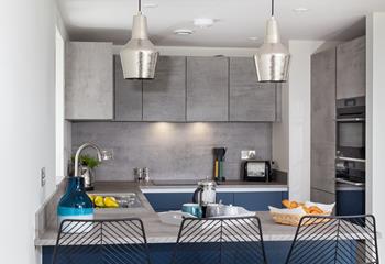 Contemporary and stylish, we love the sleek kitchen design with feature lampshades. 