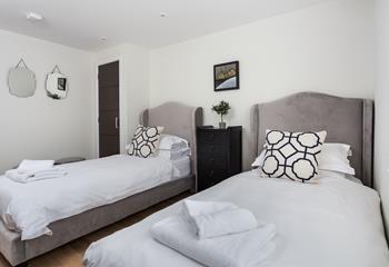 Velvet twin beds, crisp white linen and plump cushions create a relaxing space in bedroom 2. 