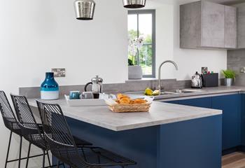 The kitchen incorporates a breakfast bar with stools, ideal for socialising while using the kitchen.