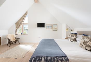 The bedroom has luxury touches such as cosy blankets and lovely cushions.