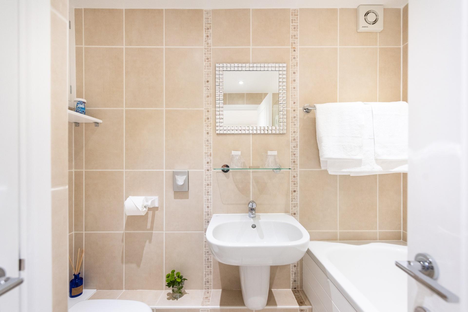 The bathroom is decorated in warm tones, giving it a spa-like feel.