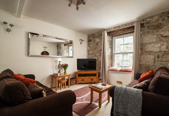 The sitting room has traditional features such as the lovely granite wall.