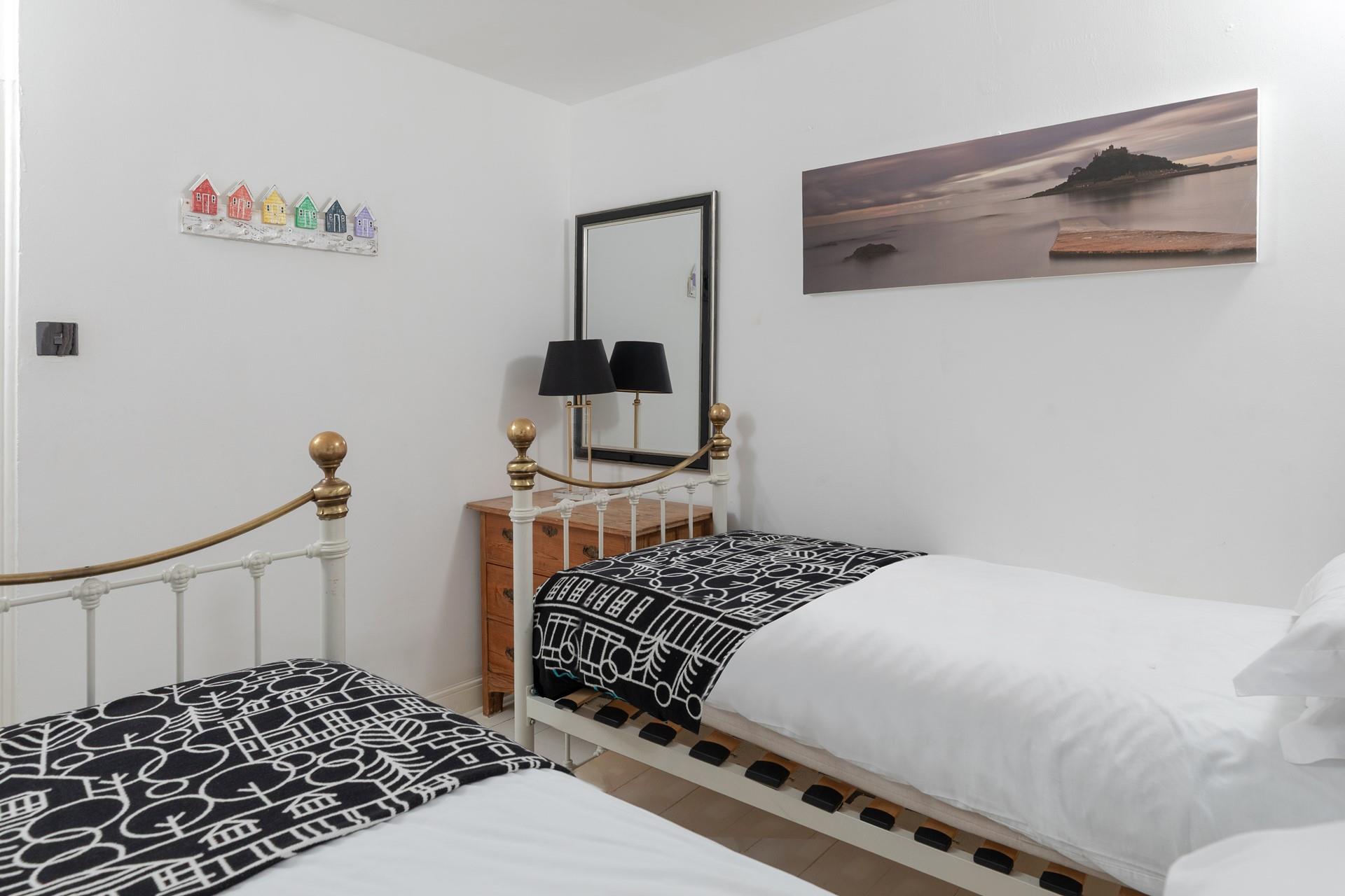 Cornish coastal artwork adorns the bedroom.