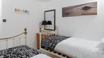 Cornish coastal artwork adorns the bedroom.