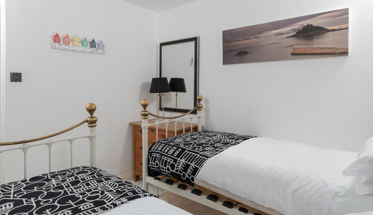 Cornish coastal artwork adorns the bedroom.