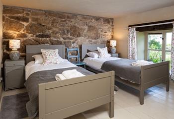 The first set of stairs lead from the kitchen diner lead you to this cosy twin bedroom. The stone wall is the perfect Cornish touch. 