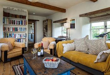 The cosy sitting room is full of character with exposed beams and traditional furnishings.