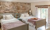 The first set of stairs lead from the kitchen diner lead you to this cosy twin bedroom. The stone wall is the perfect Cornish touch.  - Thumbnail Image