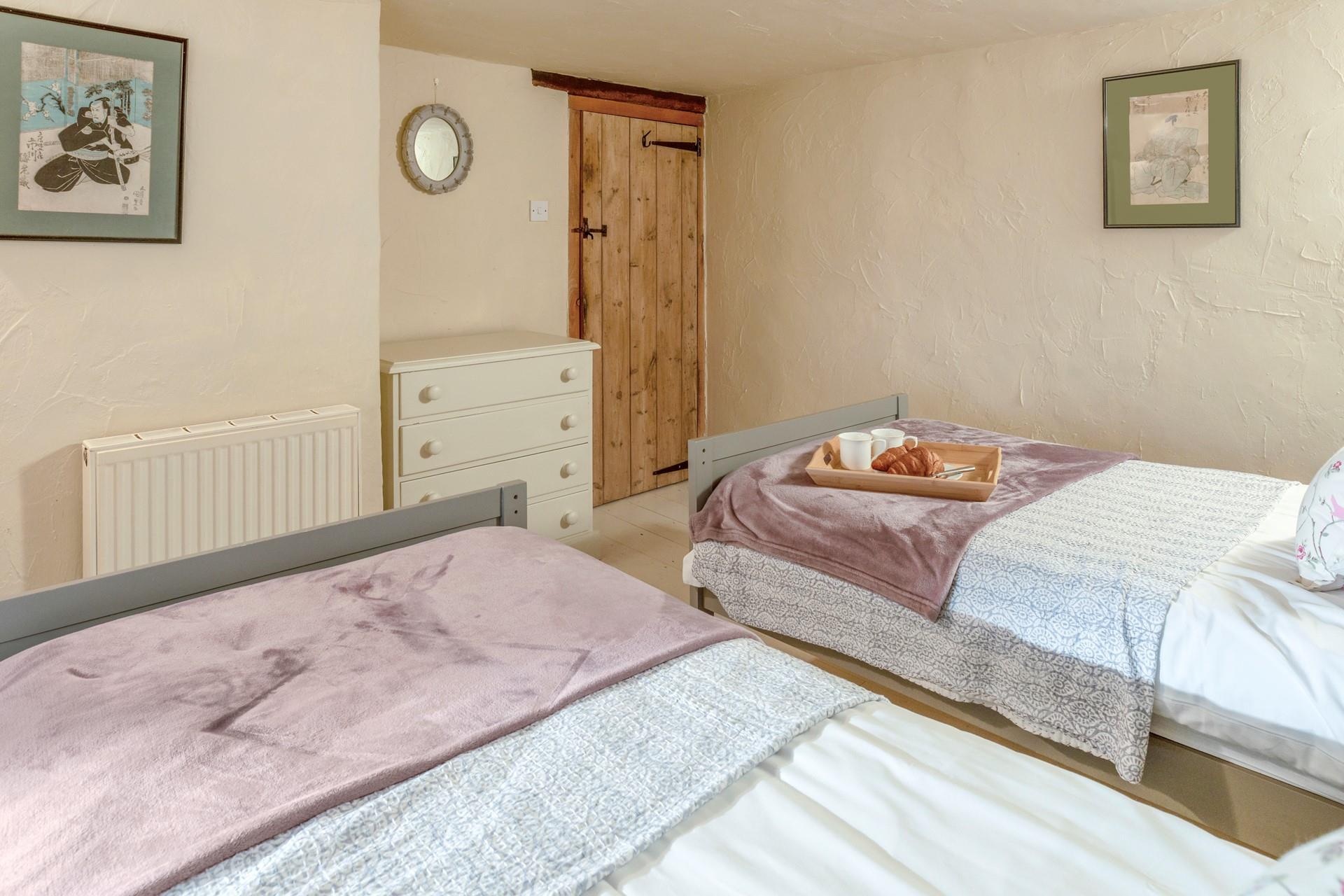 The charming twin bedroom boasts lovely cottage features.