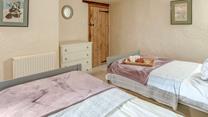 The charming twin bedroom boasts lovely cottage features.