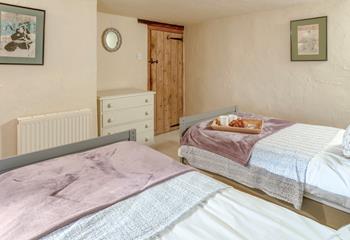 The charming twin bedroom boasts lovely cottage features.