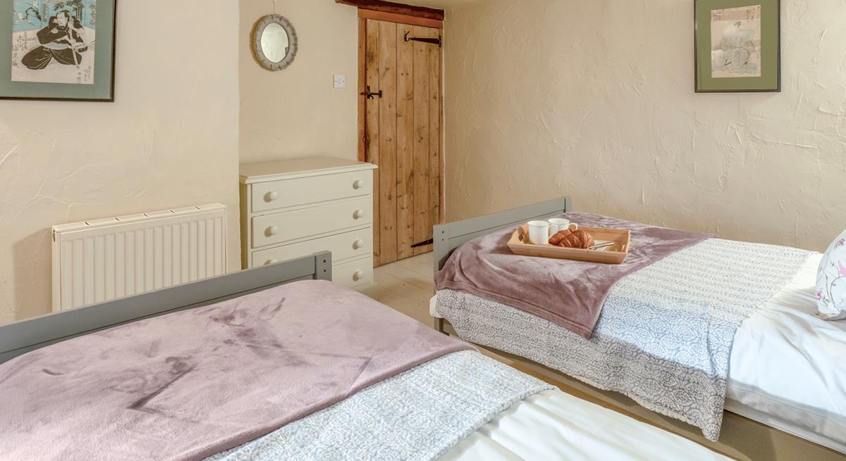 The charming twin bedroom boasts lovely cottage features.