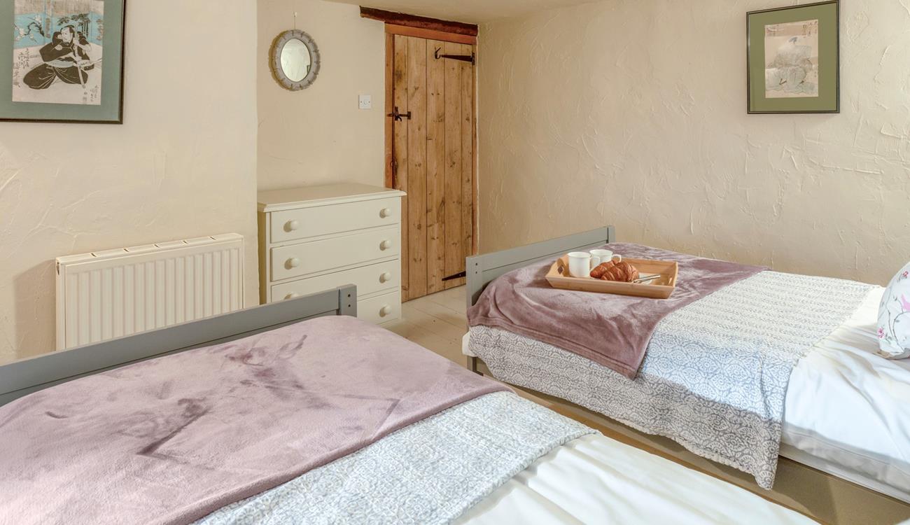 The charming twin bedroom boasts lovely cottage features.