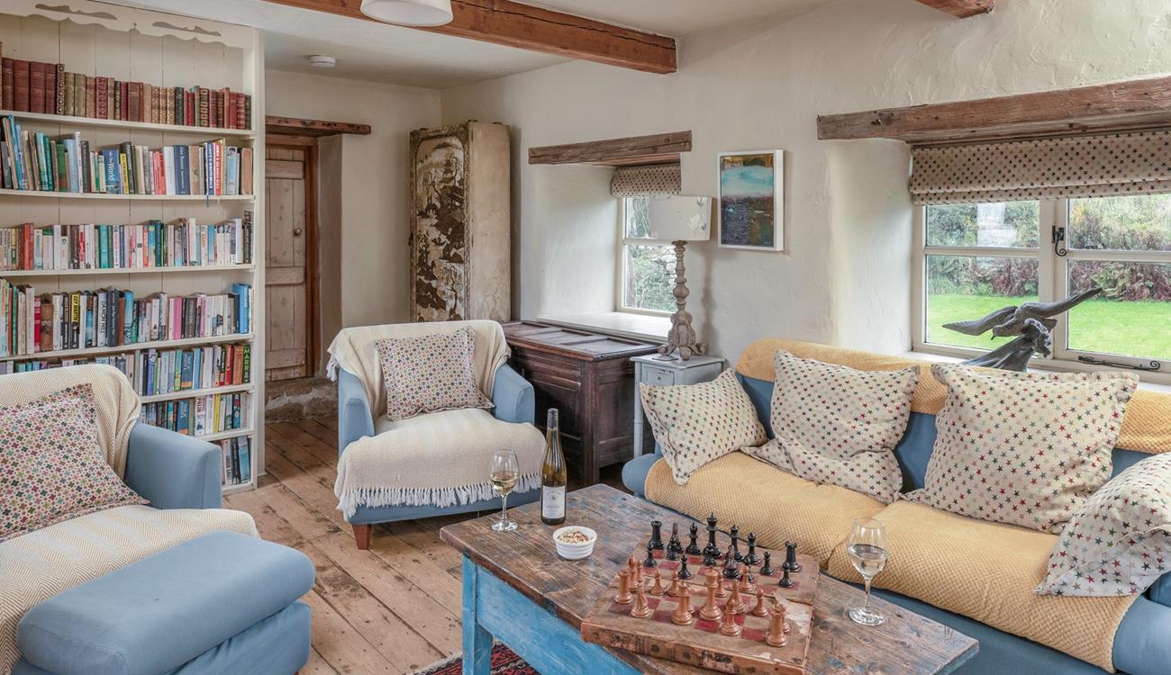 The cosy sitting room is full of character with exposed beams and traditional furnishings.