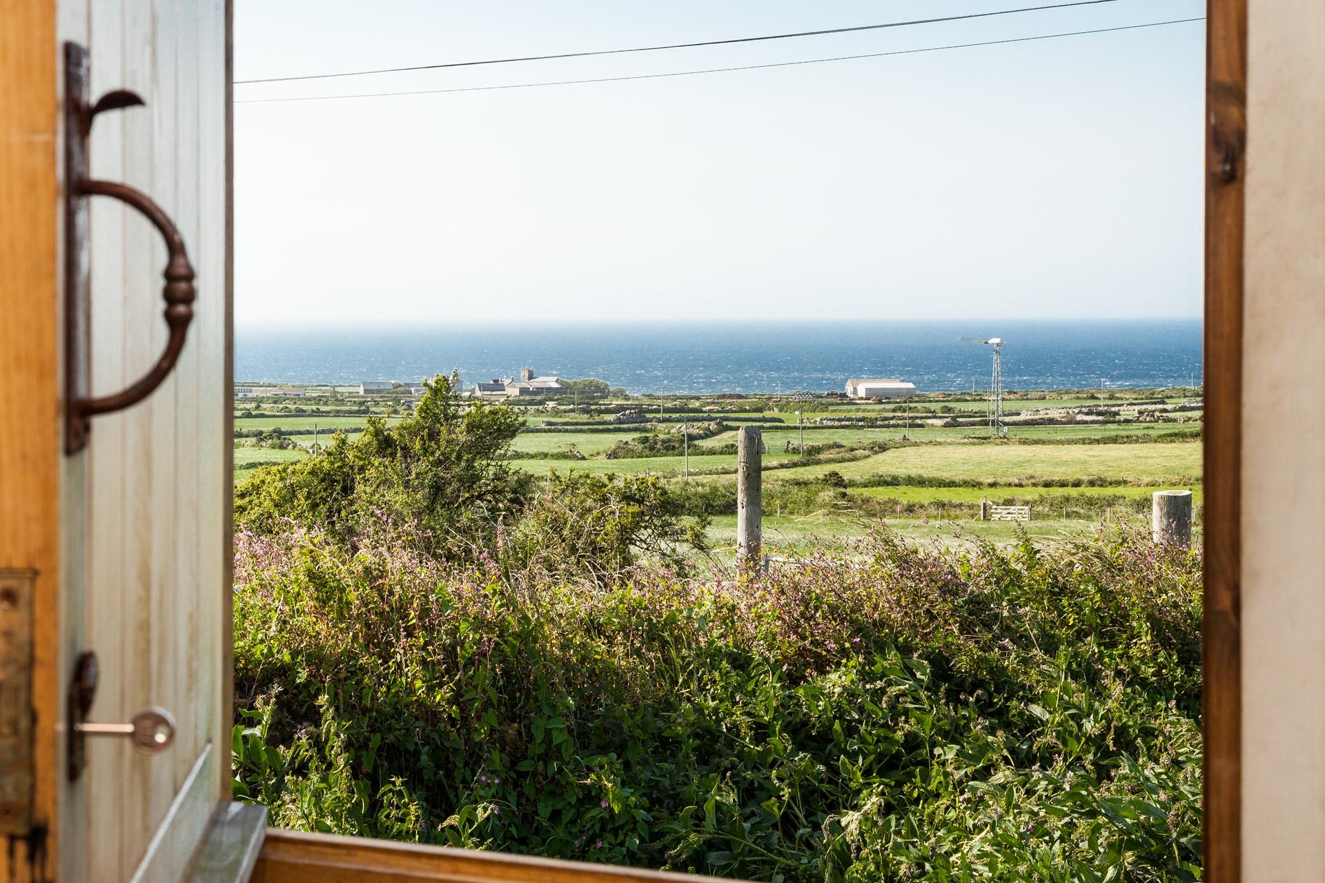 Open the front door to let the sunshine into the hut, you have the best of both worlds with views of countryside and sea.