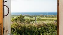 Open the front door to let the sunshine into the hut, you have the best of both worlds with views of countryside and sea.
