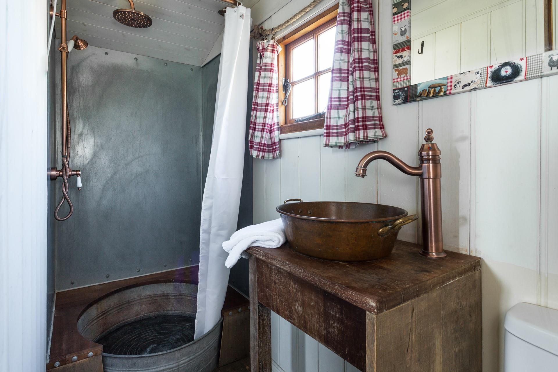 The shower room adds to the quirky and rustic finish - the shower tray is made from an old tin bath!