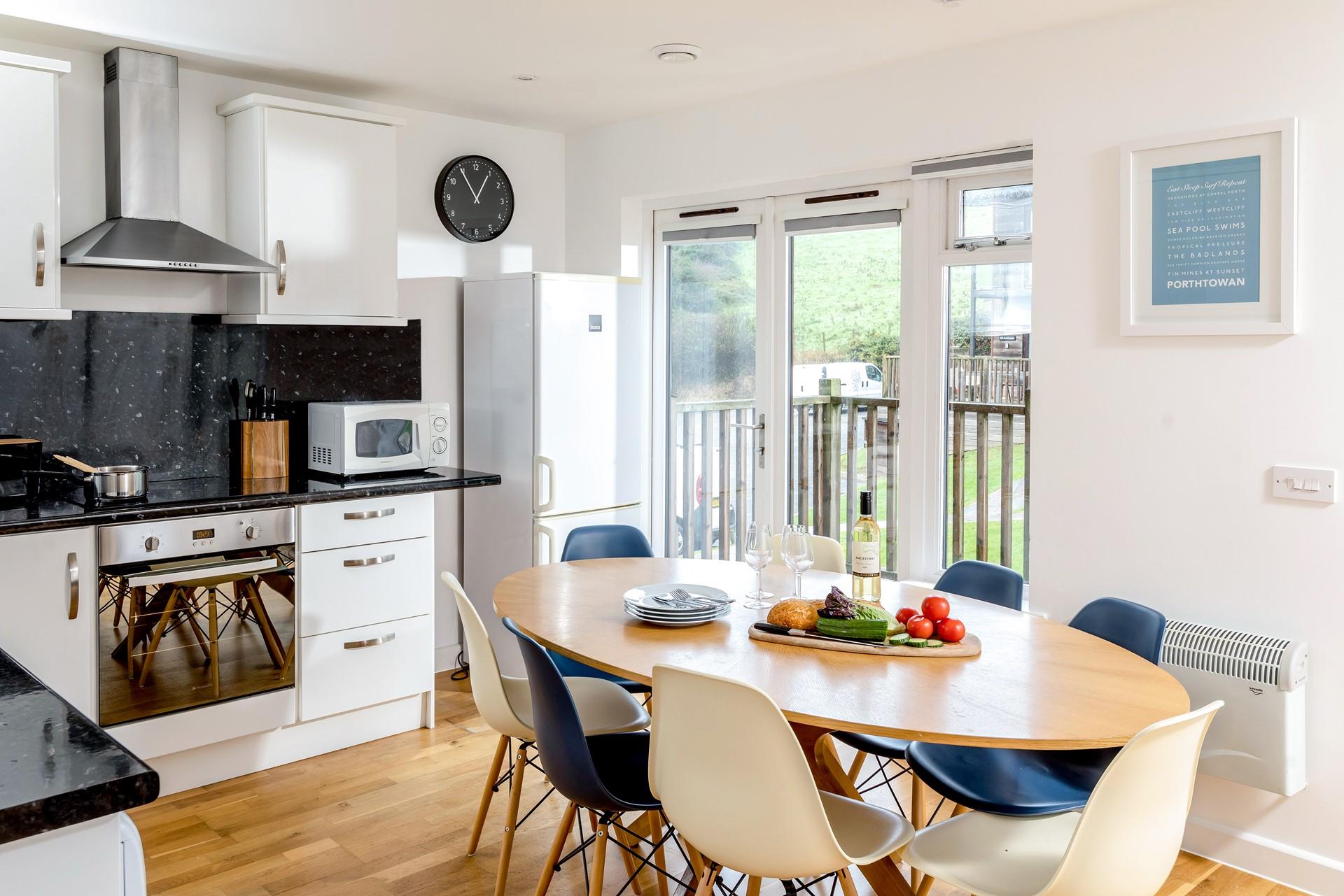 The doors leading out to the decking area allow in plenty of natural light, making the kitchen and dining area a bright and airy space.