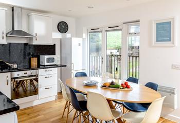 The doors leading out to the decking area allow in plenty of natural light, making the kitchen and dining area a bright and airy space.