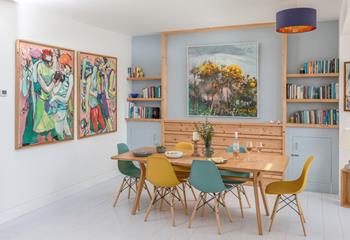 The apartment is filled with colourful artwork and books.