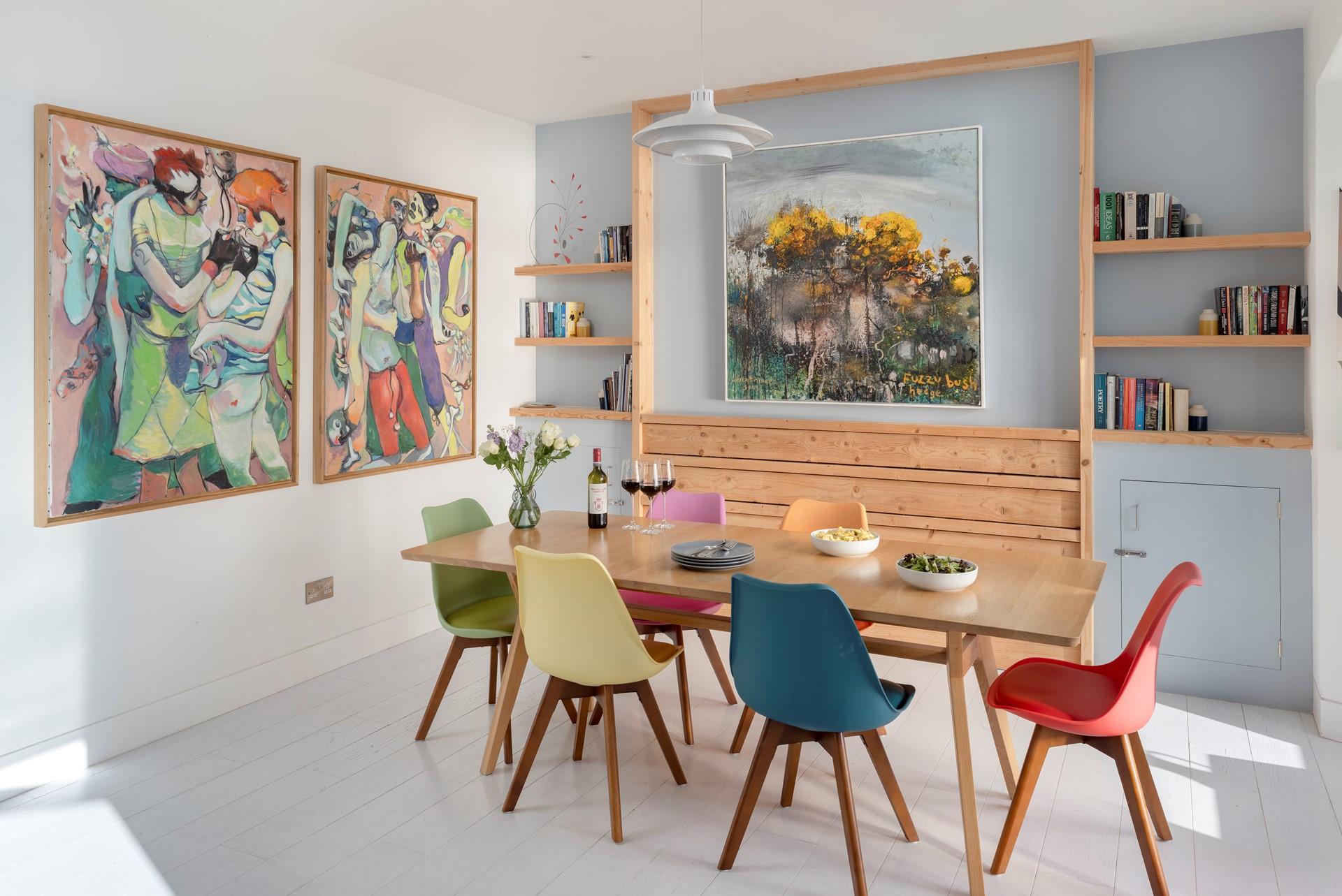 The apartment is filled with colourful artwork and books.