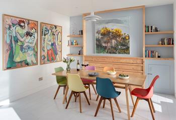 The apartment is filled with colourful artwork and books.