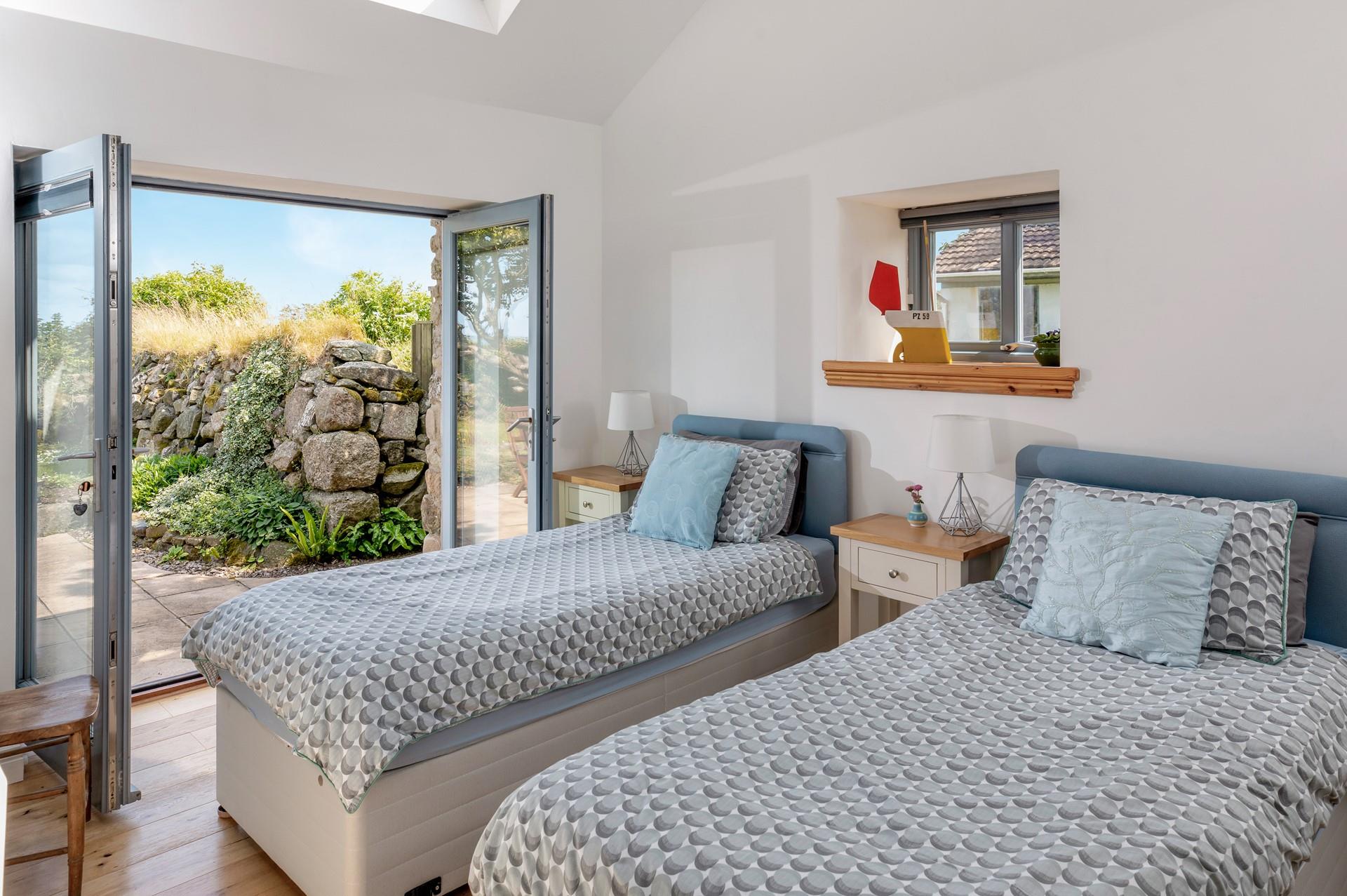 The twin bedroom has doors leading onto the patio, perfect for a morning coffee. 