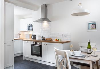 The bright kitchen is complete with a space-saving table for two.