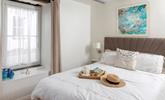 Muted tones and a large, comfortable bed make the bedroom a soothing place to unwind before drifting off to sleep. - Thumbnail Image