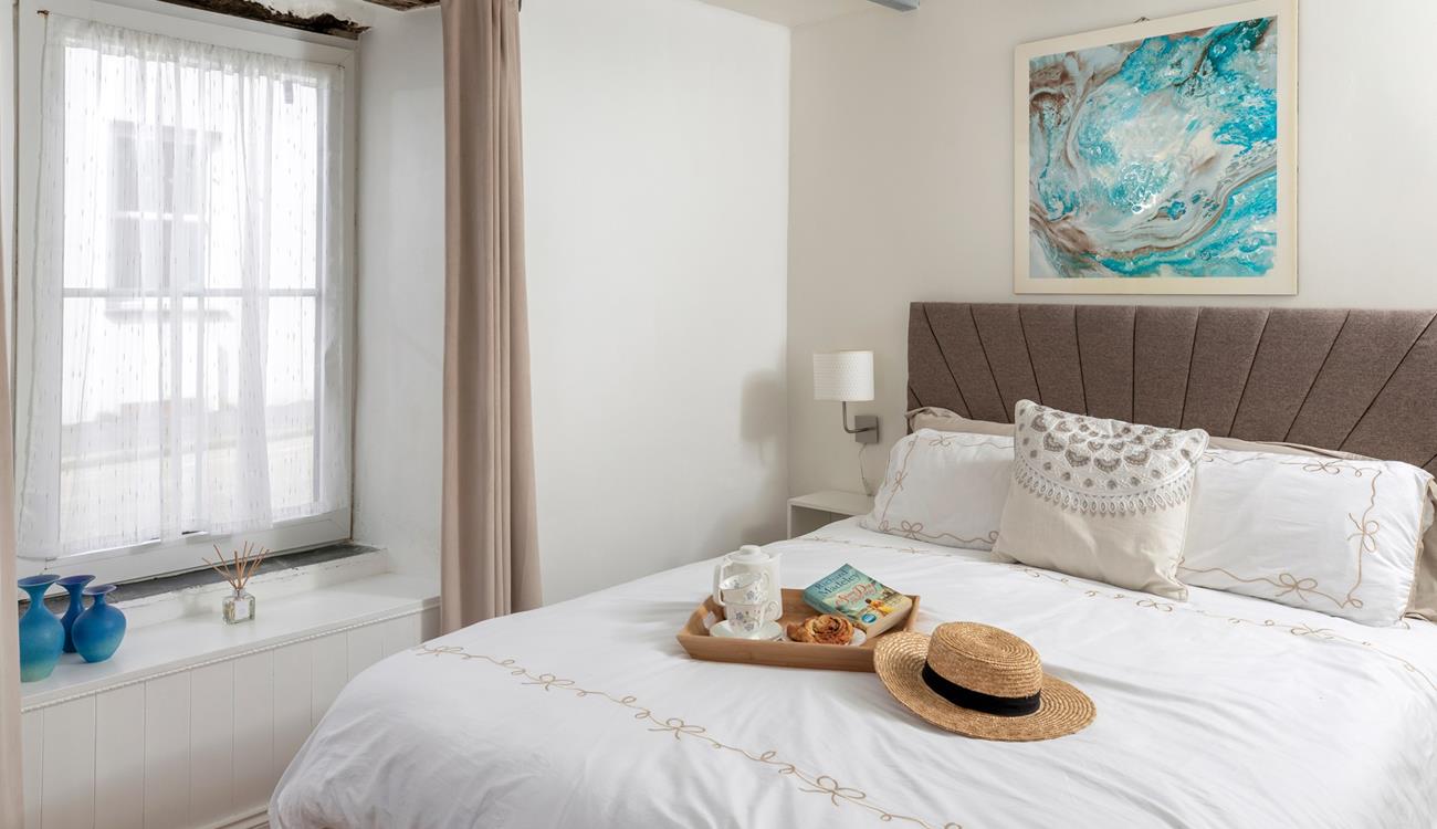 Muted tones and a large, comfortable bed make the bedroom a soothing place to unwind before drifting off to sleep.