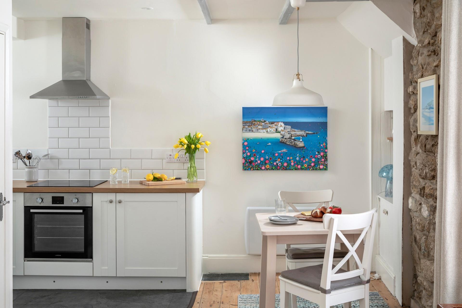 The well-equipped kitchen is complete with a space-saving table for two.