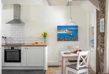 The well-equipped kitchen is complete with a space-saving table for two.