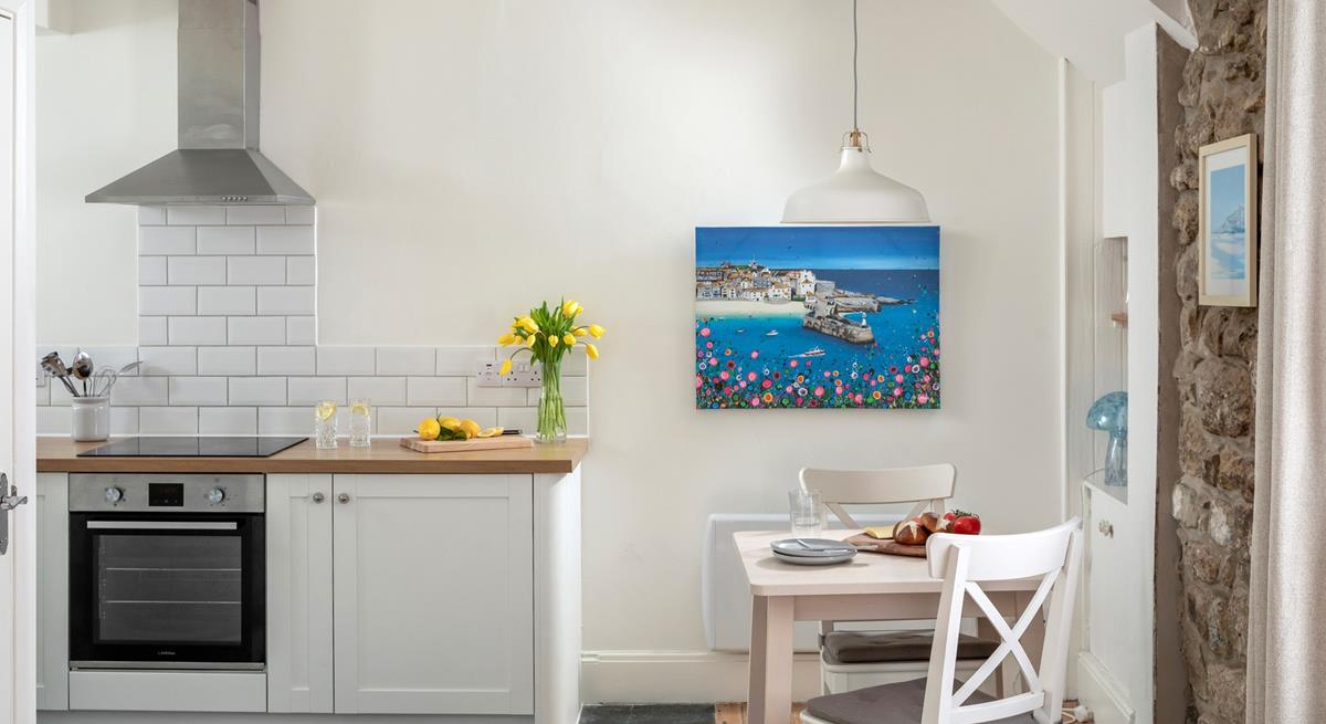 The well-equipped kitchen is complete with a space-saving table for two.