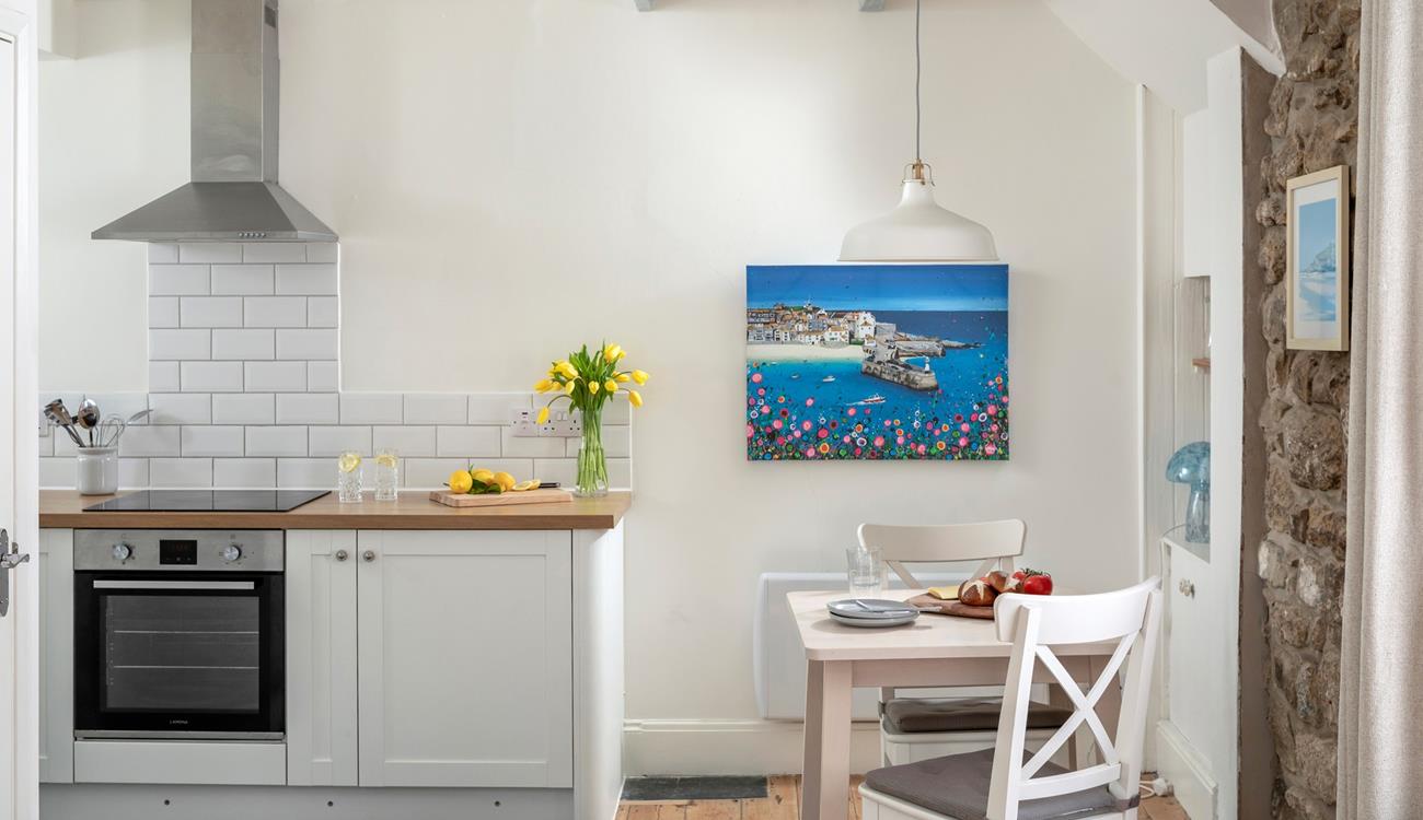 The well-equipped kitchen is complete with a space-saving table for two.