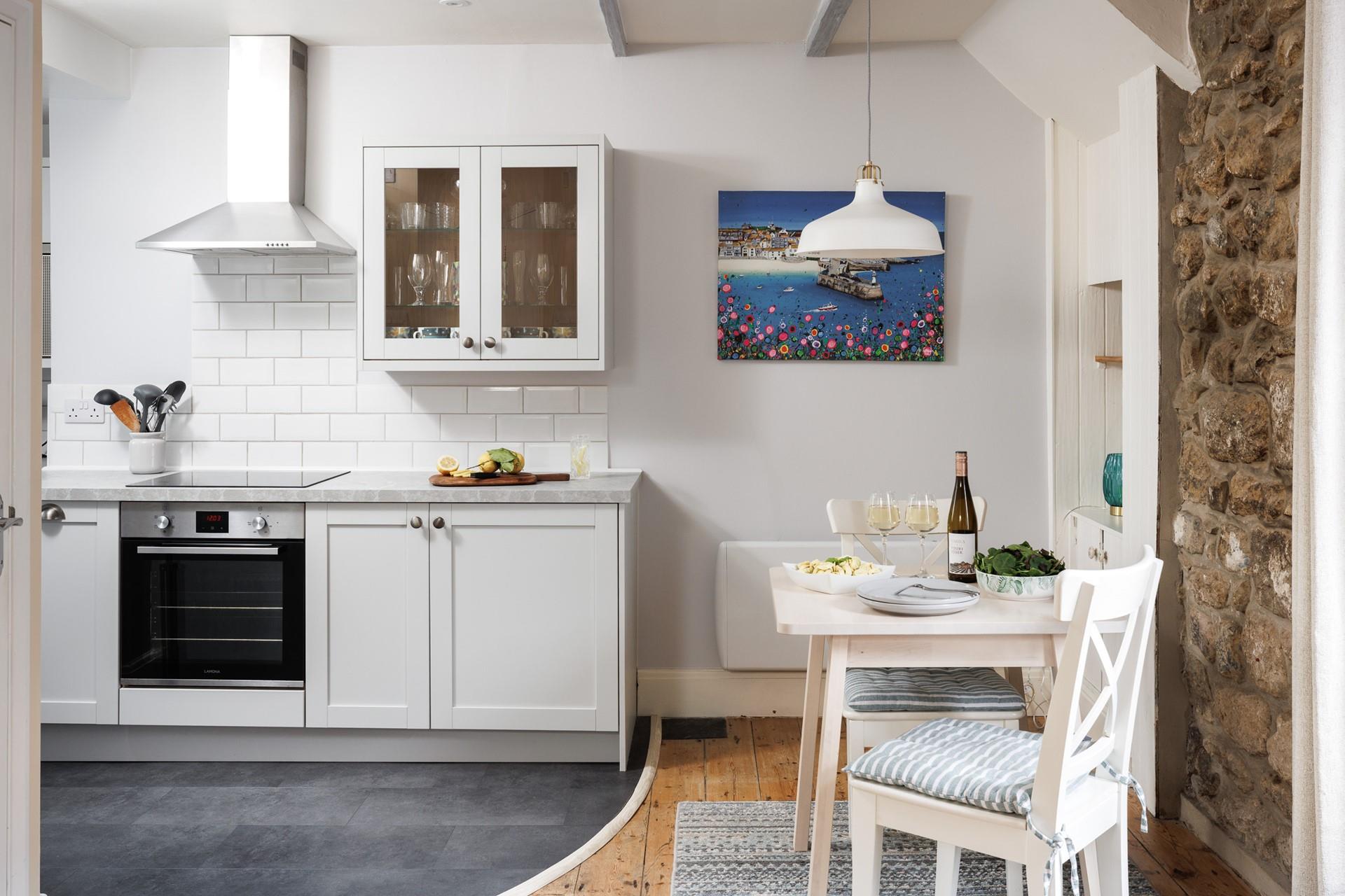 The well-equipped kitchen is complete with a space-saving table for two.