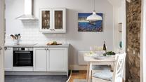 The well-equipped kitchen is complete with a space-saving table for two.