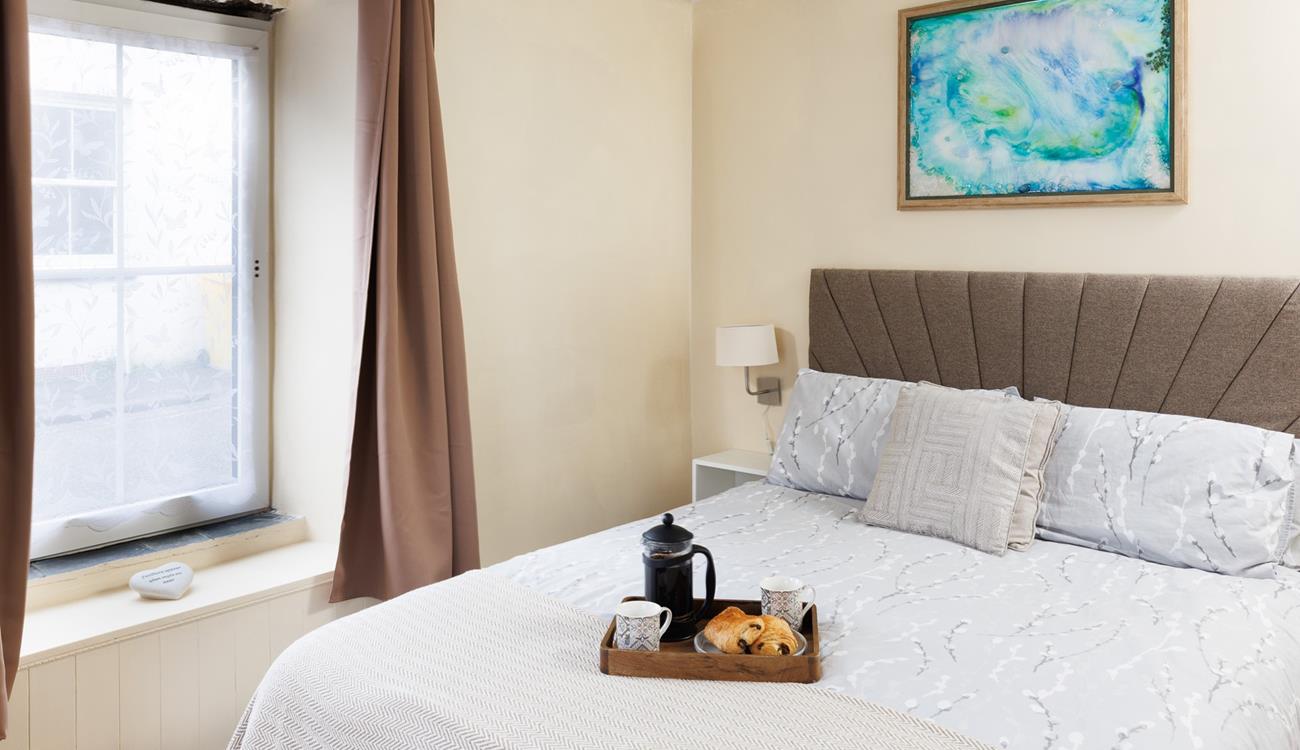 Muted tones and a large, comfortable bed make the bedroom a soothing place to unwind before drifting off to sleep.