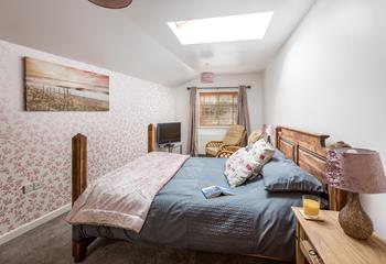 Bedroom 1 is homely featuring coastal artwork and colourful wallpaper.