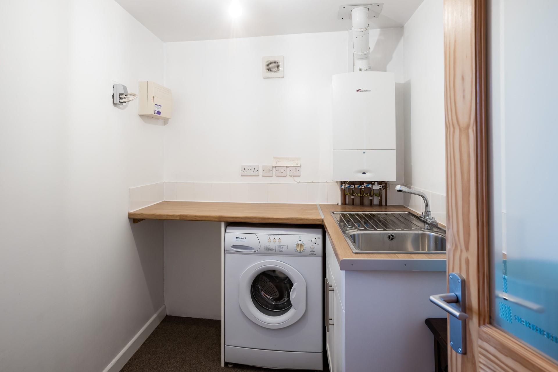 The utility area has a sink, plenty of worktops and a washing machine.