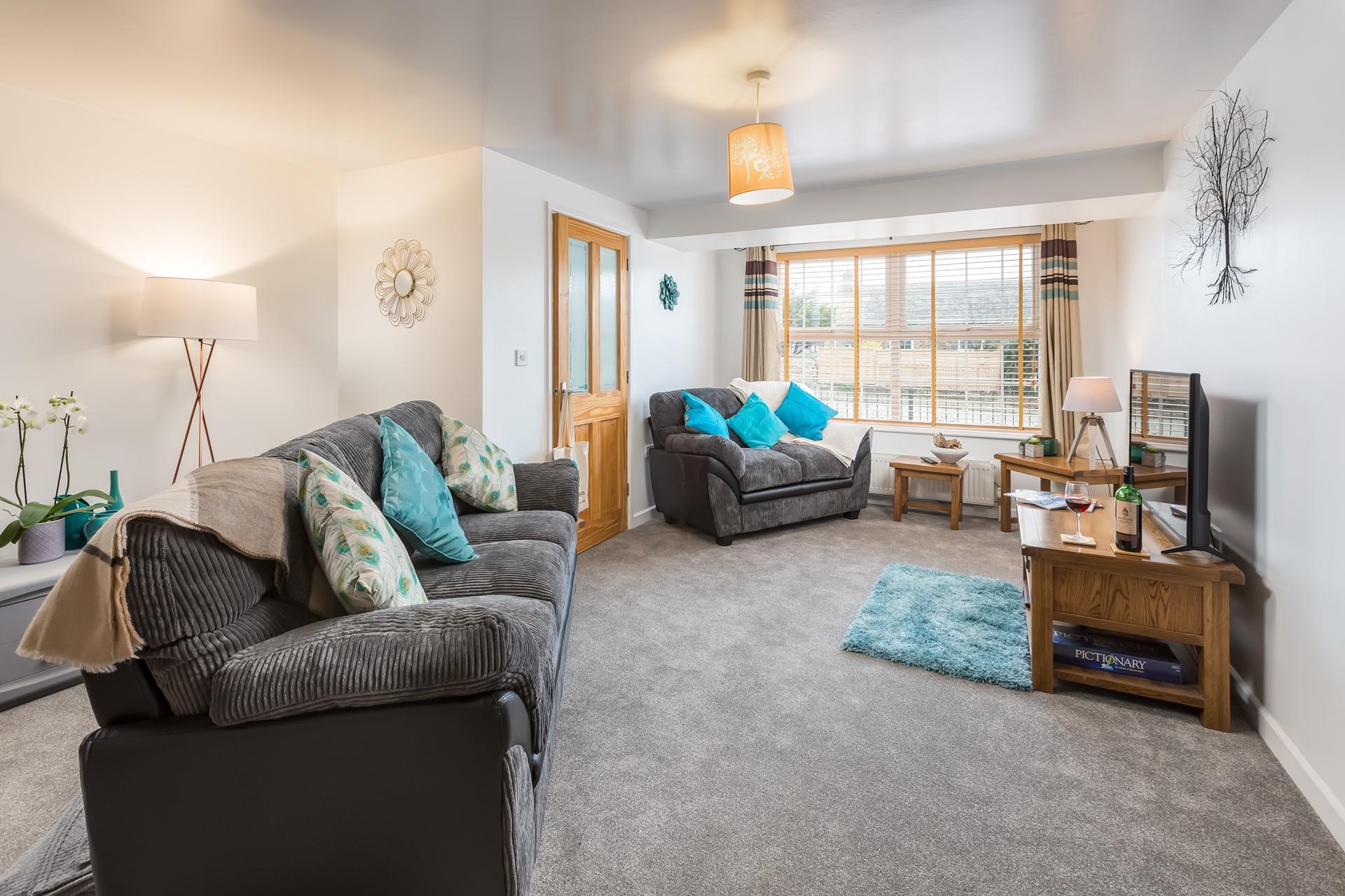 The sitting room has cosy carpets and furnishings and is the ideal base to explore North Cornwall.