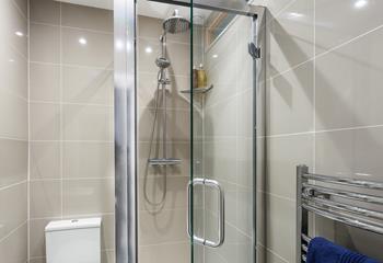 The modern shower room features a large rainfall shower head and a separate shower attachment. 