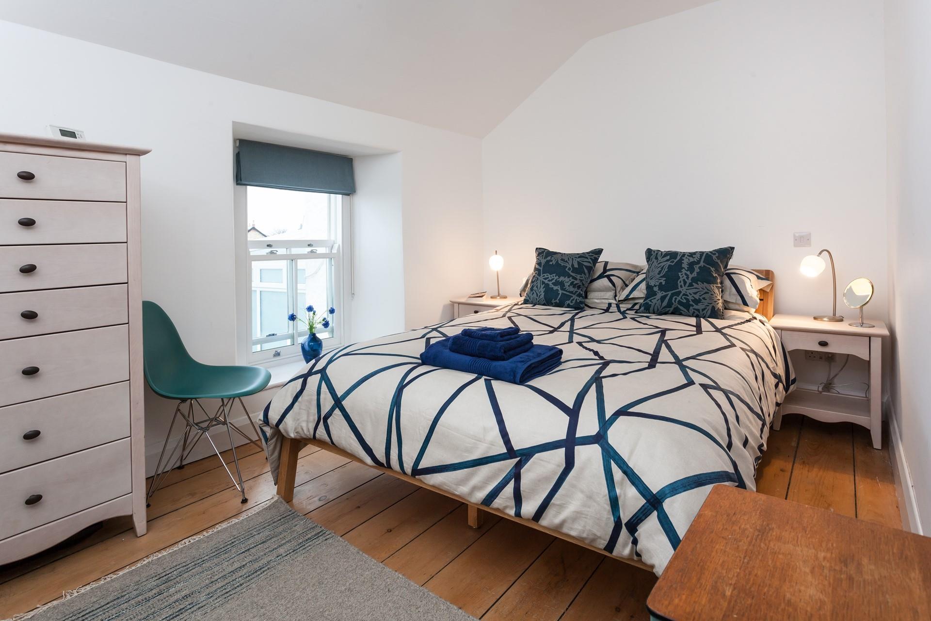Modern and stylish with exposed floorboards, bedroom 1 offers sea views from the window. 