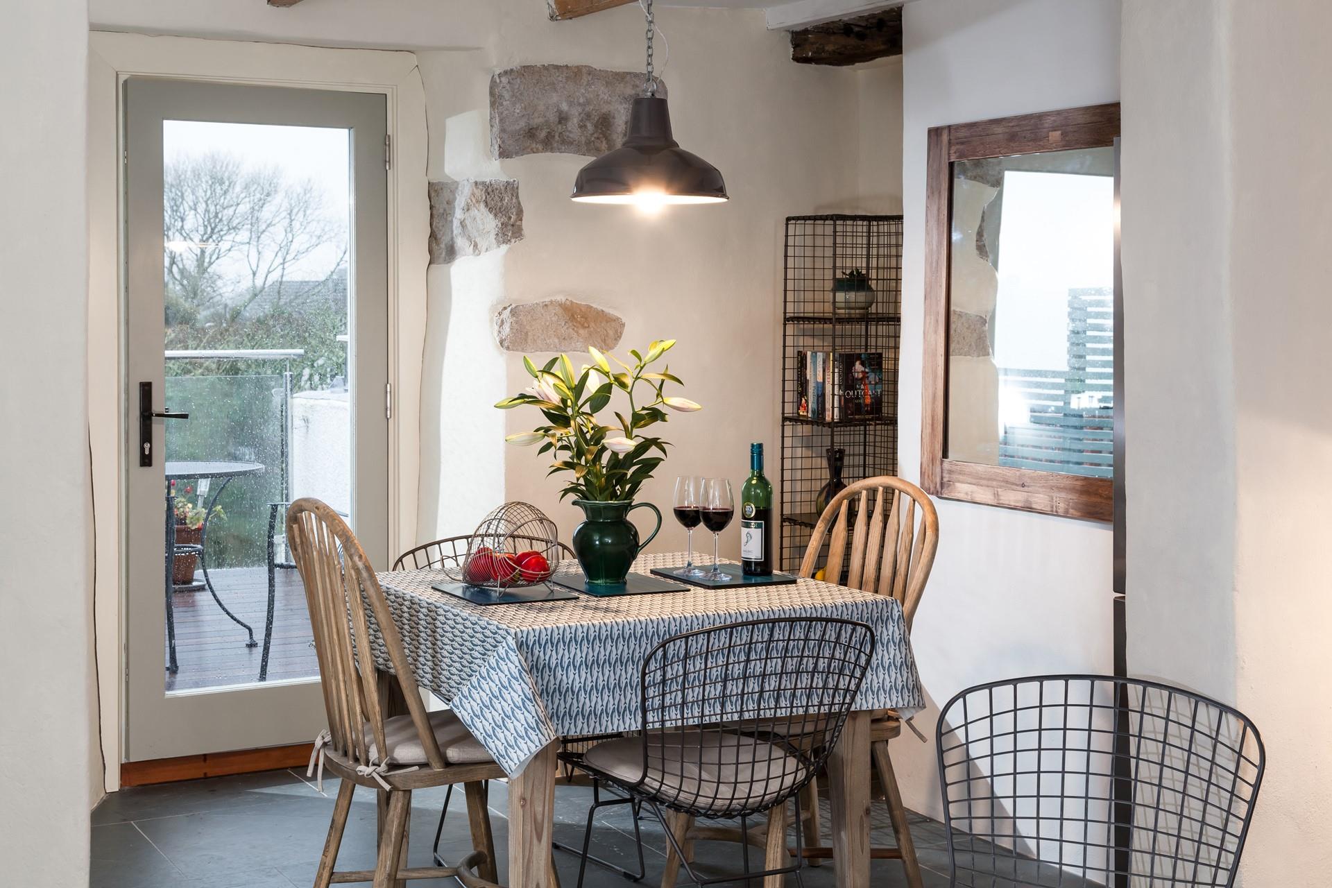 Mismatched chairs and exposed granite create a rustic finish in the dining area. 