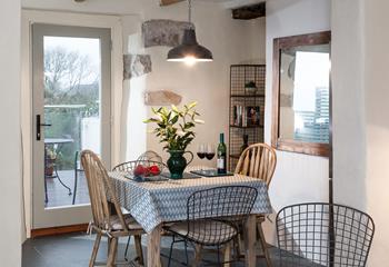 Mismatched chairs and exposed granite create a rustic finish in the dining area. 