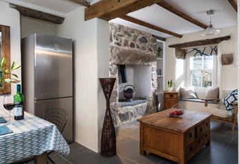 The open plan living-kitchen area features a beautifully crafted wooden chest table, perfectly complimenting the granite feature fireplace.