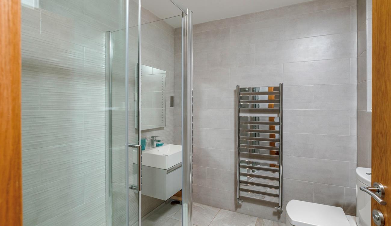 The shower room boasts a luxurious rainfall shower, perfect for washing away beach days!