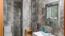The marble effect tiles and modern fixtures give the ensuite an indulgent, spa-like feel.